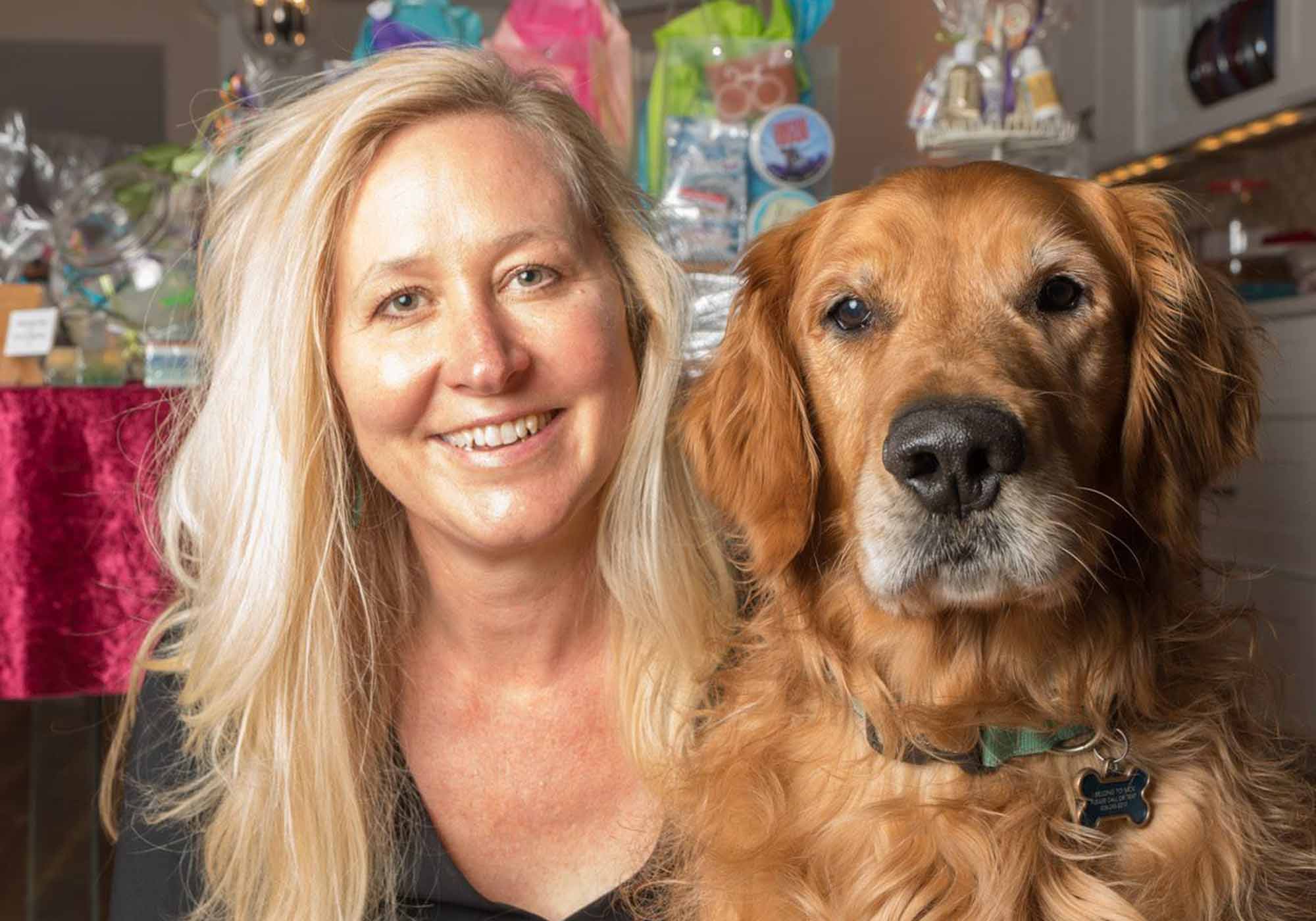 Woman with blond hair with golden retriever dog.