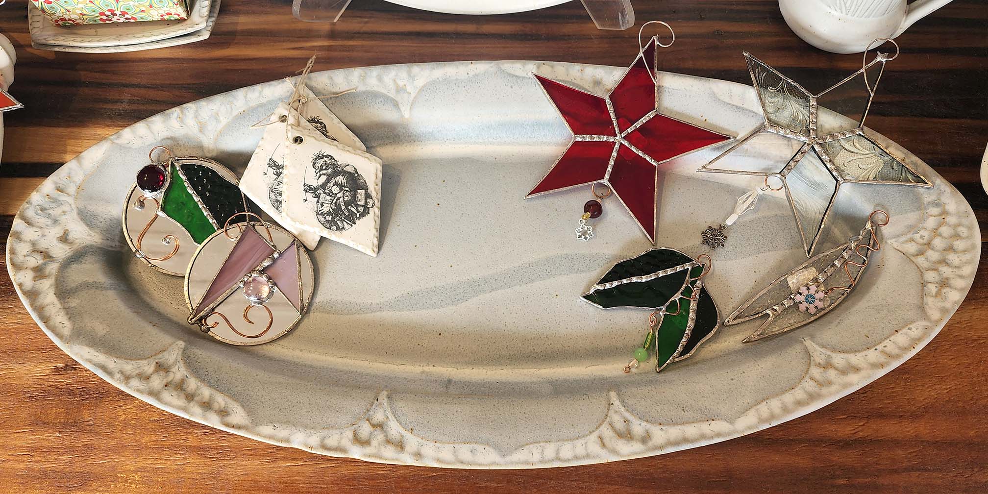 white platter displayed with glass ornaments and ceramics ornaments at Hamilton Williams Gallery.
