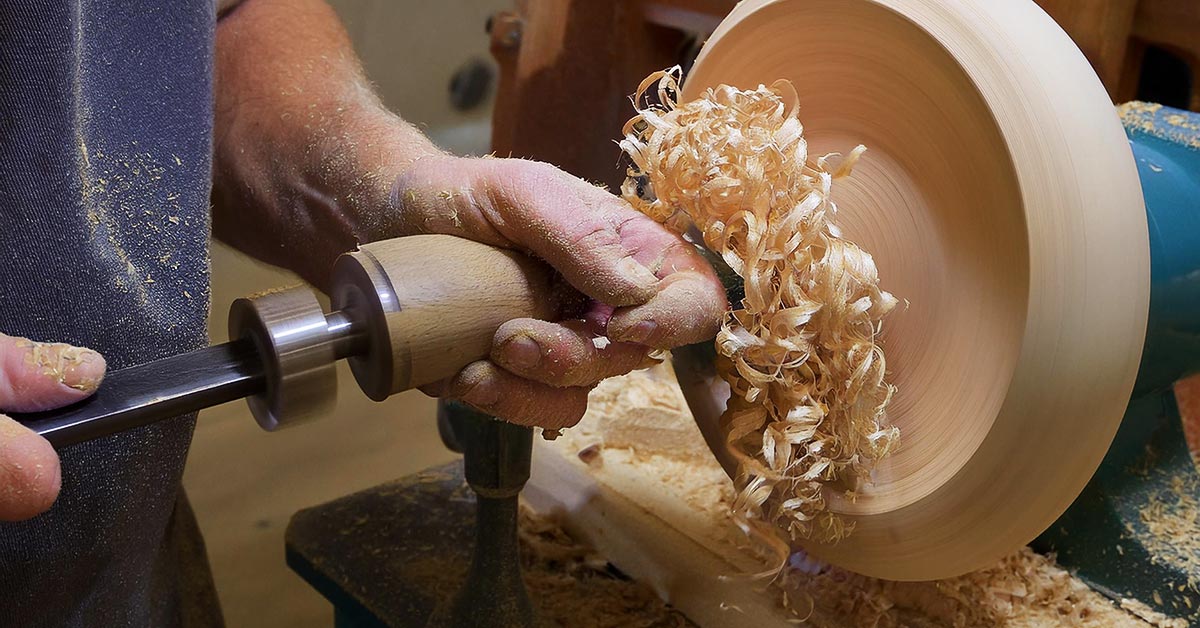 A hand-turned wooden bowl made from Ambrosia Maple sitting on a white and gray surface, as seen from overhead.