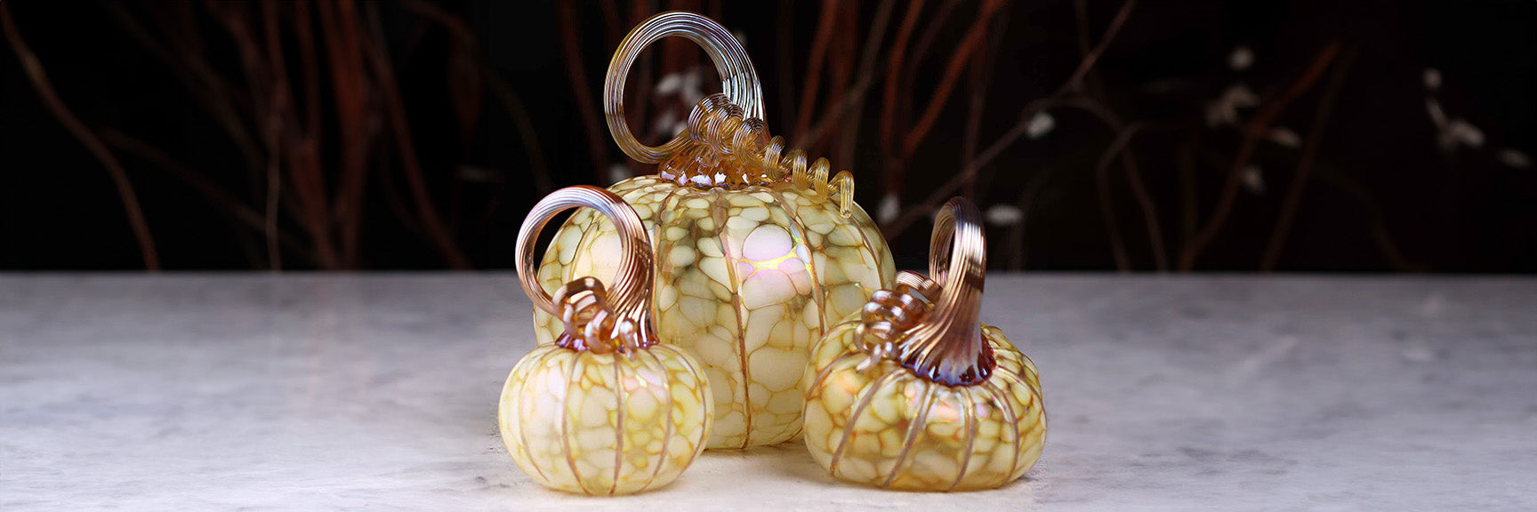 Decorative glass pumpkins on a neutral background